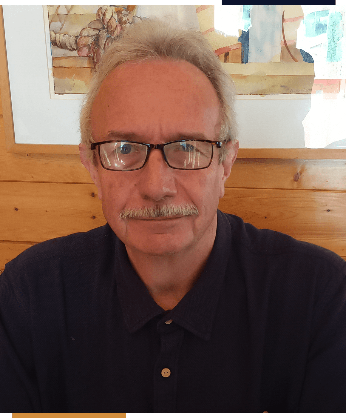 Man sitting in front of a wooden wall